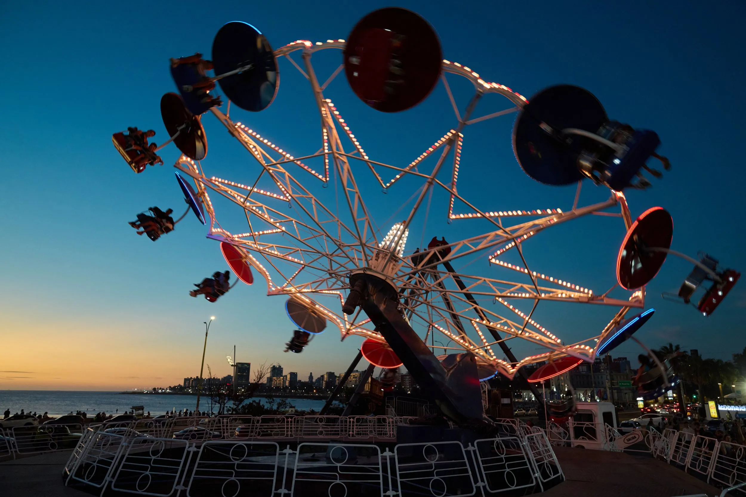 The swing ride at Parque Rodó lit up against the evening sky
