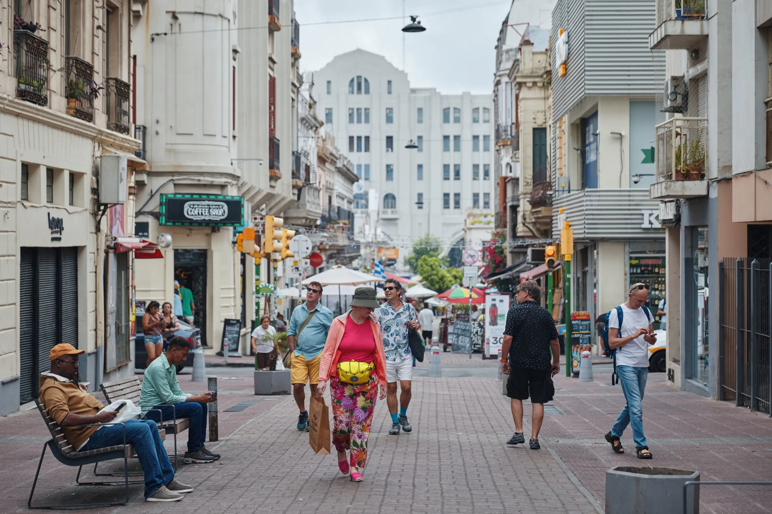 People walking down a pedestrian street in Ciudad Vieja, among the old buildings