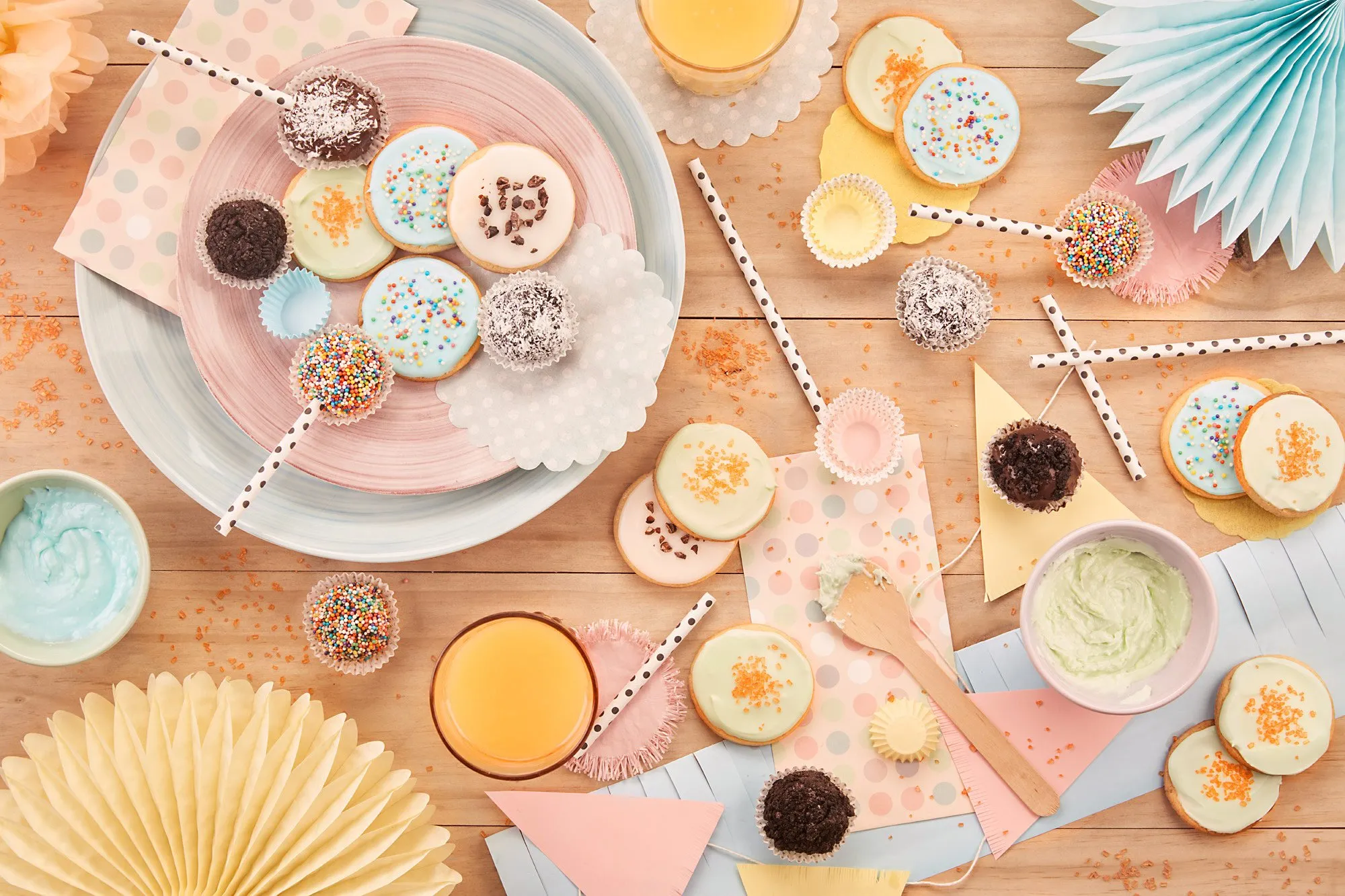 A table decorated with sweets, cupcakes, cookies, drinks, and decorations for a birthday party