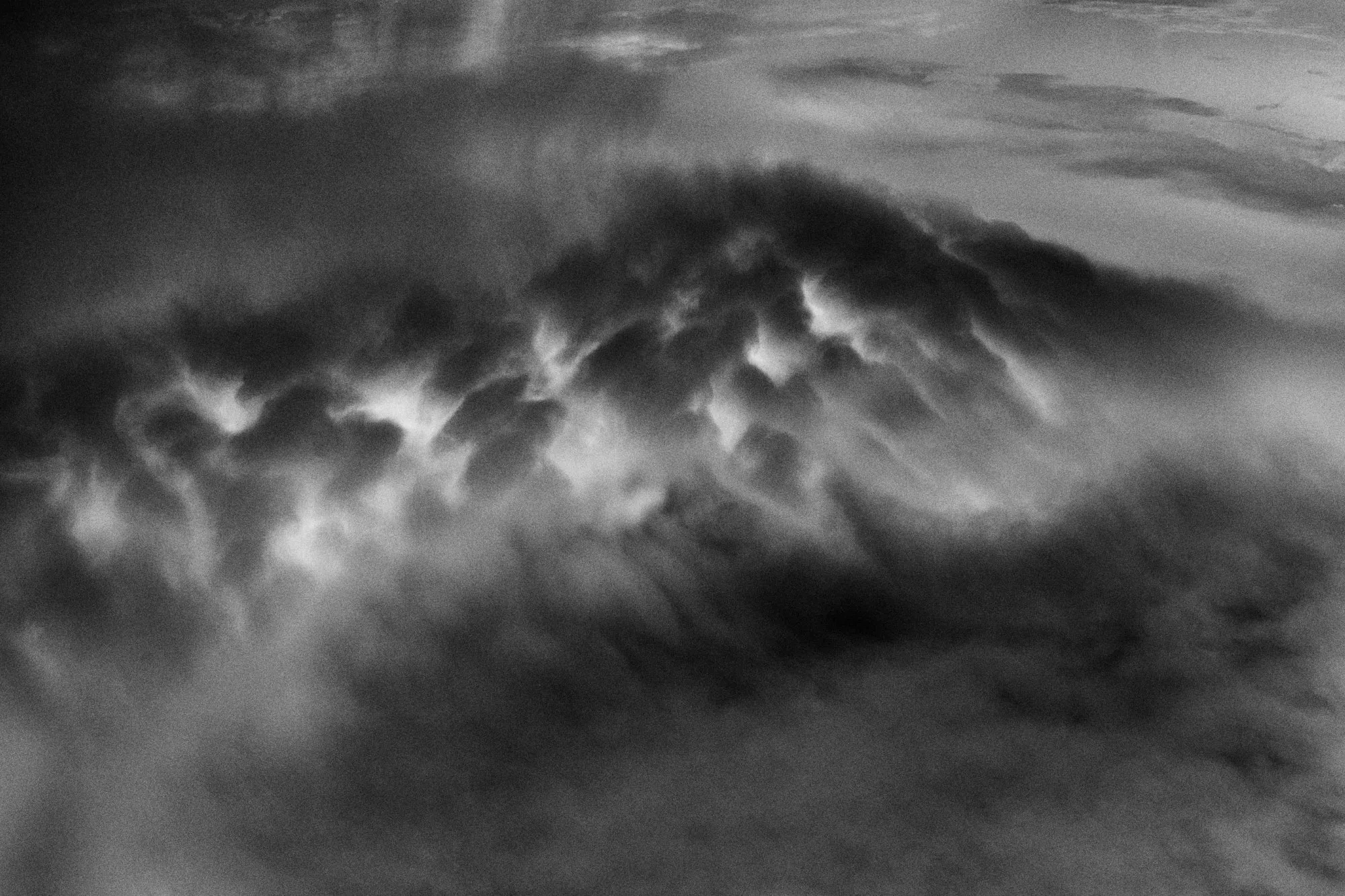 A churning sky that looks like the mouth of a volcano, in black and white